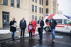 LH-Stellvertreterin Mag.a Christine Haberlander, Dr. Walter   Aichinger, Leopold mit Urkunde, Urban Schneeweiß in Rotkreuz-Uniform, Landeshauptmann Mag. Thomas Stelzer und Mag. Thomas Märzinger stehen vor einem großen Gebäude auf einem Parkplatz, im Hintergrund ein Rettungswagen des Roten Kreuzes