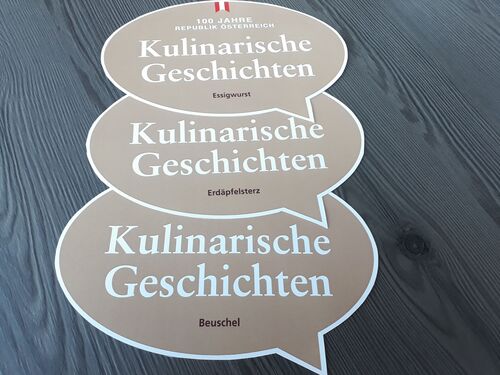 Drei in Form einer Sprechblase gestaltete Kärtchen mit der Aufschrift:  „100 Jahre Republik Österreich - Kulinarische Geschichten“
