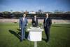 Landesrat Markus Achleitner, Landeshauptmann Mag. Thomas Stelzer und Siegmund Gruber auf dem Rasen des Fußballstadions, davor ein Modell des Neubaus