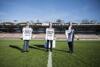 Landesrat Markus Achleitner, Landeshauptmann Mag. Thomas Stelzer und Siegmund Gruber auf dem Rasen des Fußballstadions, alle präsentieren ein T-Shirt mit Aufschrift 2022 Oberösterreich bzw. 2022 Raiffeisen Arena