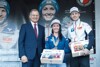 LH Stelzer bei der Geschenkübergabe an Jacqueline Seifriedsberger und Michael Hayböck vor einem Werbeplakat beim Empfang in Hinzenbach.