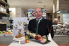 Landesrat Max Hiegelsberger in einem Lebensmittelgeschäft, vor ihm ein Tisch mit Brot und Obst und eine Vorlegeplatte mit Wurst und Käse