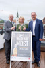 Landesrat Max Hiegelsberger, Edeltraud Huemer und Gerald Hackl stehen nebeneinander auf einer Dachterrasse, jeder hält ein schönes Glas mit Most in der Hand, davor eine Schild mit Beschriftung Wild auf Most