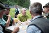 Landesrat Max Hiegelsberger im Gespräch mit den Bewirtschaftern der Hinteren Sandlingalm an einem Tisch auf der Alm.