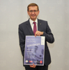 Landesrat Markus Achleitner zeigt das Plakat zum Kursprogramm, Aufschrift Weiterbildung voller Energie