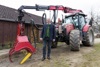 Landesrat Max Hiegelsberger vor einem großen Traktor mit einem Maschinenaufsatz zur Holzbringung