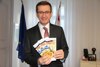 Wirtschafts- und Europa-Landesrat Markus Achleitner mit dem EDM-Kochbuch „28 traditionelle Rezepte“.