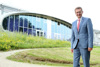 Wirtschafts- und Forschungs-Landesrat Markus Achleitner steht vorm Gebäude der FH Hagenberg