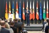 Landesrat Markus Achleitner steht auf einer Bühne vor Publikum und spricht in ein Mikrofon, im Hintergrund Bundesländer- und EU-Fahnen