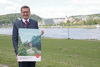 Landesrat Markus Achleitner im Donaupark Linz, in Händen ein Werbeplakat zur Kampagne, Aufschrift: Drinnen ist Wäscheberg, draußen ist Bergerlebnis
