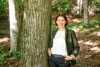 Landesrätin Michaela Langer-Weninger steht in einem Wald an einen Baum gelehnt
