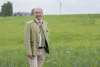 Landesrat Max Hiegelsberger in einer Wiese mit Korn- und Mohnblumen