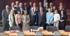 Landtagspräsident Max Hiegelsberger und Dr. Johannes Hahn stehen mit weiteren 19 Personen in zwei Reihen in einem Konferenzraum