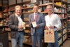 Karl Lehner, Landesrat Markus Achleitner und Alfred Mayr stehen nebeneinander vor einem Regal mit verschiedenen verpackten Lebensmitteln