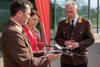 Feuerwehr-Landesrätin Michaela Langer-Weninger stehend im Gespräch mit zwei Feuerwehrmännern, von denen einer eine Drohne in der Hand hält.