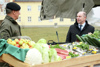 Brigadier Dieter Muhr und Landesrat Max Hiegelsberger neben einer großen Holzkiste mit Lebensmitteln: Äpfel, Kraut, Fleisch, Fische, Gurken