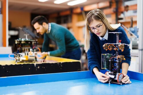 Junge Frau und junger Mann arbeiten an Elektronik