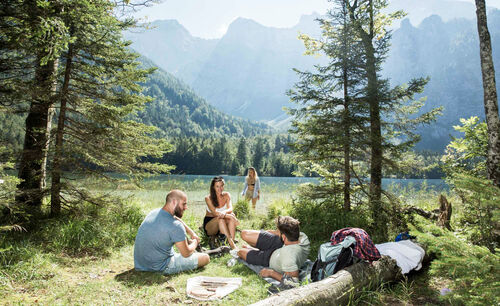 Vier Menschen picknicken am Hinteren Langbathsee im Salzkammergut.