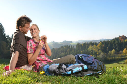 Frau und Mann bei einer Wanderpause in herbstlicher Landschaft