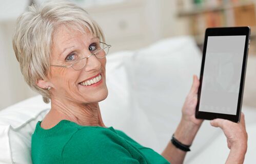 Eine von einem Tablet begeisterte Seniorin