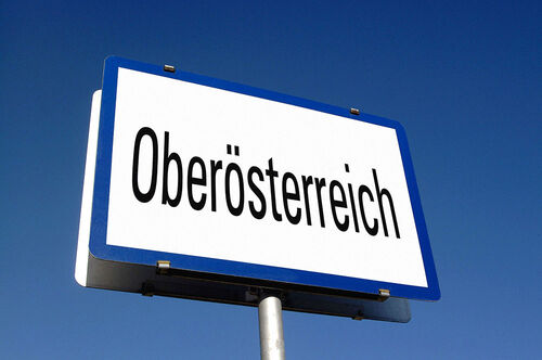Blau gerahmte weiße Ortstafel mit der Aufschrift „Oberösterreich“