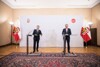 Landeshauptmannstellvertreter Manfred Haimbuchner und Landeshauptmann Thomas Stelzer stehend bei der Pressekonferenz im Braunen Saal des Landhauses.