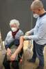 weißhaarige über 80-jährige Frau wird geimpft