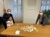 Dr.in Petra Haslgrübler, das Kind Maja und Landesrat Max Hiegelsberger an einem Tisch, auf dem verstreut Memo-Spielkarten liegen
