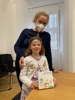 Dr.in Petra Haslgrübler und das Kind Maja mit einer Spielschachtel mit der Aufschrift: Bienenfreundliche Bäume und Sträucher