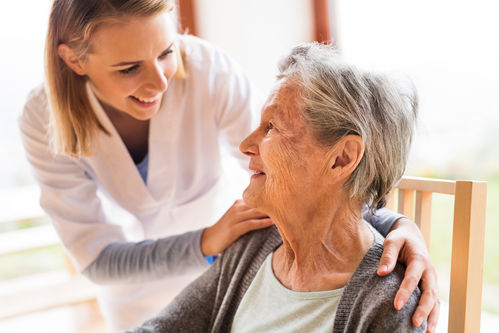 Eine junge Pflegerin kümmert sich um eine alte Frau