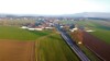 Ortsdurchfahrt der Ortschaft Koberg aus der Vogelperspektive, Straße führt durch eine Ansiedlung von Bauernhöfen