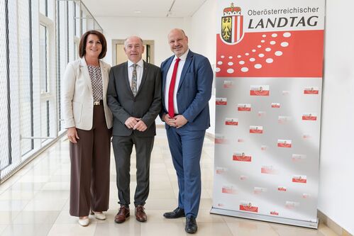 Zweite Landtagspräsidentin Sabine Binder, Landtagspräsident Max Hiegelsberger und dritter Landtagspräsident Peter Binder stehen neben einem Rollup mit der Aufschrift „Oberösterreichischer Landtag“