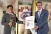 Hildegard Prem - mit dem Energy Globe-Preis - und Landesrat Markus Achleitner halten eine Urkunde