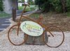 Stilisiertes Rad aus Eisen in Originalgröße auf einem Rad-Parkplatz, auf ihm montiert ist ein Schild mit Beschriftung Haager Lies reloaded