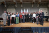 Gruppenfoto mit 23 Personen in zwei Reihen auf einer mit Fahnen geschmückten Bühne, darunter Landeshauptmann Mag. Thomas Stelzer und Mag.a Margot Nazzal 