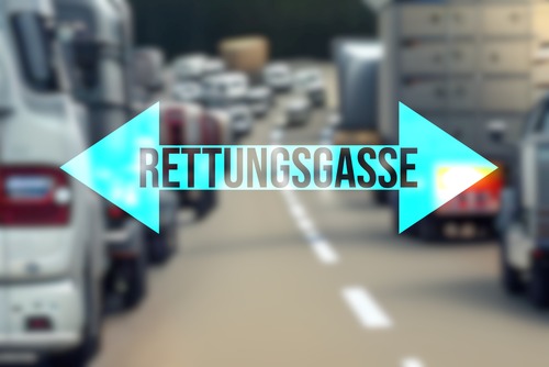 Stau auf einer Autobahn, mittig ein doppelseitiger Pfeil mit Beschriftung Rettungsgasse