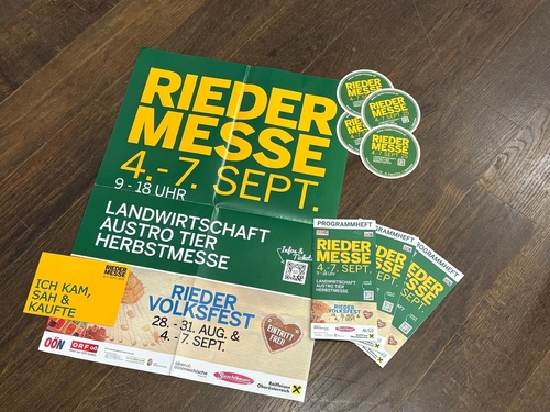 Broschüren und Plakat zur Rieder Messe liegen auf einem Tisch