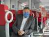 LR Günther Steinkellner mit Mund-Nasen-Schutz auf einem Sitzplatz in einer S-Bahn-Garnitur