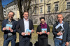 Mag. Norbert Rainer (Klimabündnis OÖ), Umwelt- und Klima-Landesrat Stefan Kaineder, Mag.a Christina Huber-Prunthaller (MASI) und Bmstr. Ing. Johann Staudinger (STS Fertigteile) freuen sich über ein großes Netzwerk der Klimabündnis-Betriebe in OÖ und stehen in einem Park und dahinter befindet sich das Linzer Landhaus.