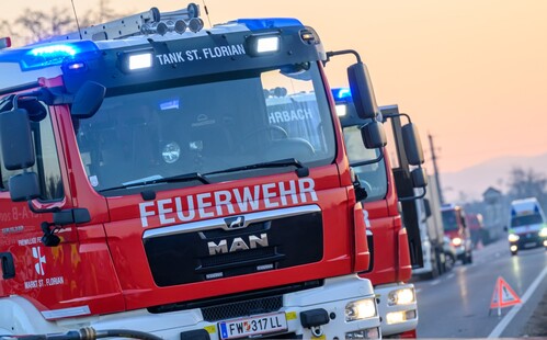 Feuerwehr-Lastwägen während eines Einsatzes auf einer Bundesstraße.