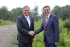 Lenzing-AG-Vorstand DI Christian Skilich und Wirtschafts- und Energie-Landesrat Markus Achleitner stehen nebeneinander auf einem Waldweg und geben einander die rechte Hand.