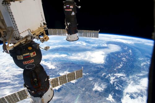Blick vom Weltraum auf die Erde: Raumkapseln angedockt an der ISS über den Alpen
