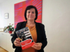 Landesrätin Birgit Gerstorfer hält den Katalog in Händen, Aufschrift auf der Titelseite: OÖ Sozialratgeber 2021