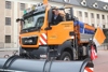 Landesrat Steinkellner sitzt bei geöffneter Fahrertür in einem Schneeräumfahrzeug der Straßenmeisterei Gmunden, im Hintergrund Hausfassade mit Fenstern. 