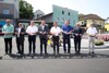 Acht Männer stehen nebeneinander in einem Kreisverkehr und durchneiden ein Eröffnungsband, Landesrat Mag. Günther Steinkellner dritter von rechts