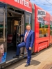 Landesrat Mag. Günther Steinkellner steht beim Einstieg in eine Straßenbahn, diese ist beschriftet mit Mobil ans Ziel, die Mobilitätsinitiative OÖ