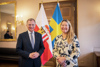 Landeshauptmann Thomas Stelzer mit Schwedens Botschafterin Annika Lisa Markovic stehen in einem Saal im Linzer Landhaus, dahinter zwei Fahnen – OÖ, Schweden.