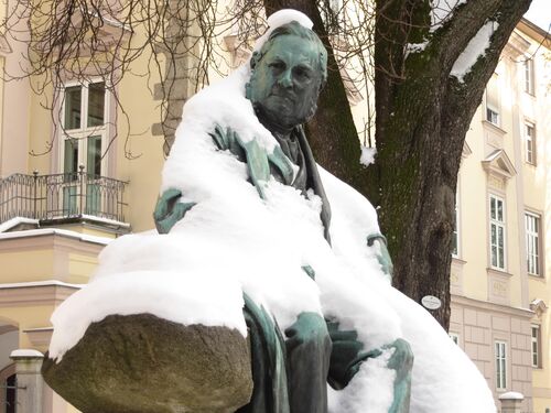 Adalbert-Stifter Denkmal im winterlichen Kleid vor dem Kulturdenkmal Landhaus im Linzer Promenadenpark