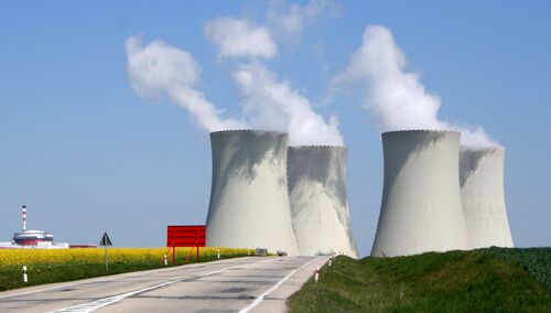 Vier Kühlturme eines Atomkraftwerkes, aus denen Dampf steigt