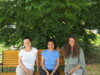 Karola Klausner, Ana Luz Morales de la Rosa und Anita Eyth sitzen auf einer Parkbank, hinter ihnen ein großer Strauch